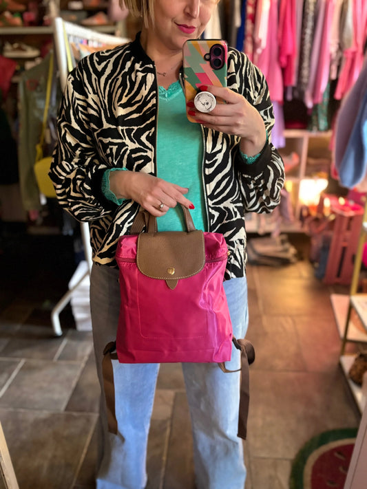 Person holding a pink bag with a zebra print jacket in a store setting