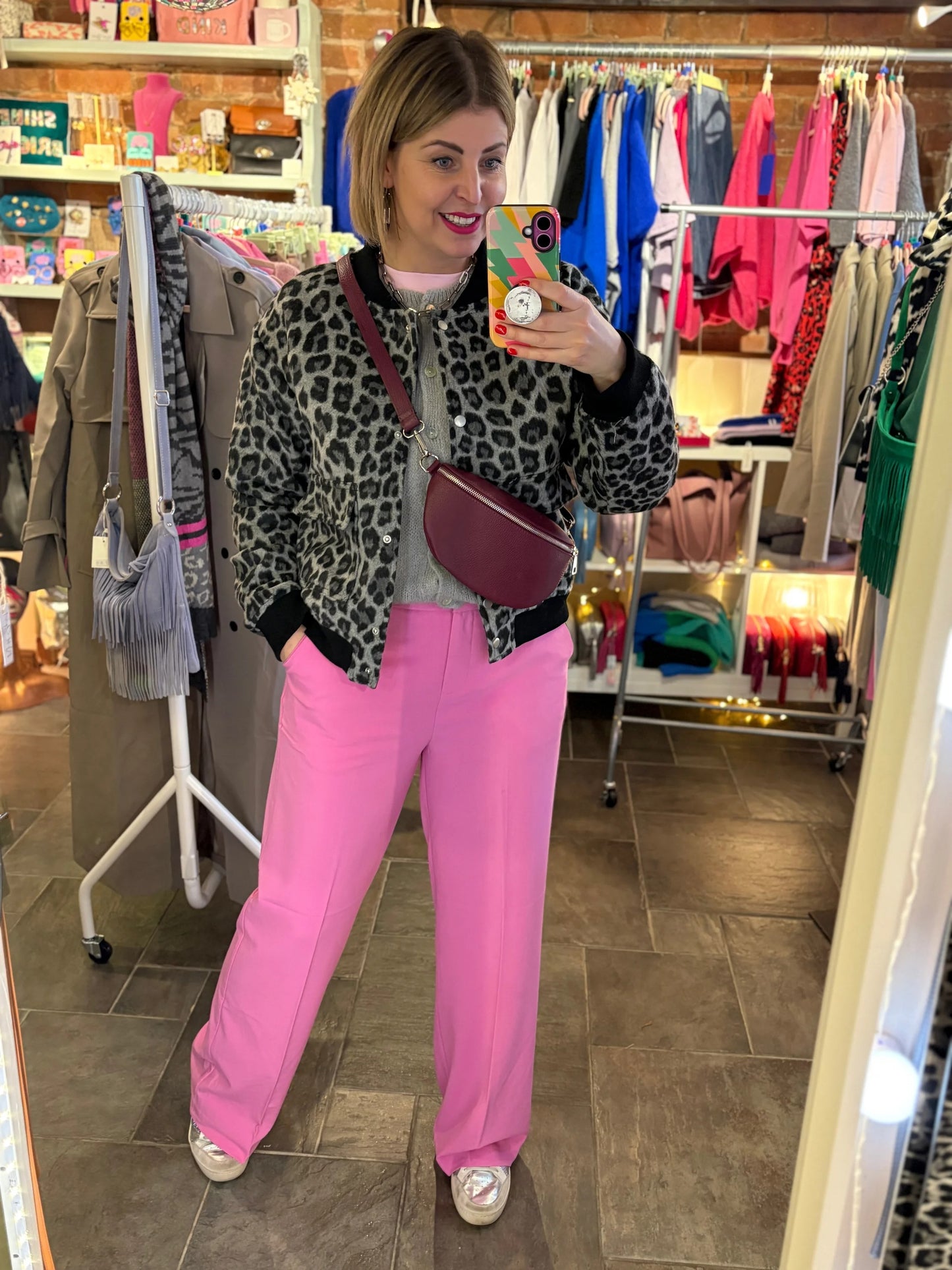 Person wearing a leopard print jacket and pink pants in a store setting