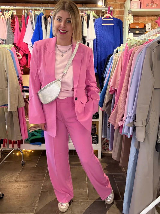 Person wearing a pink suit standing in a clothing store.