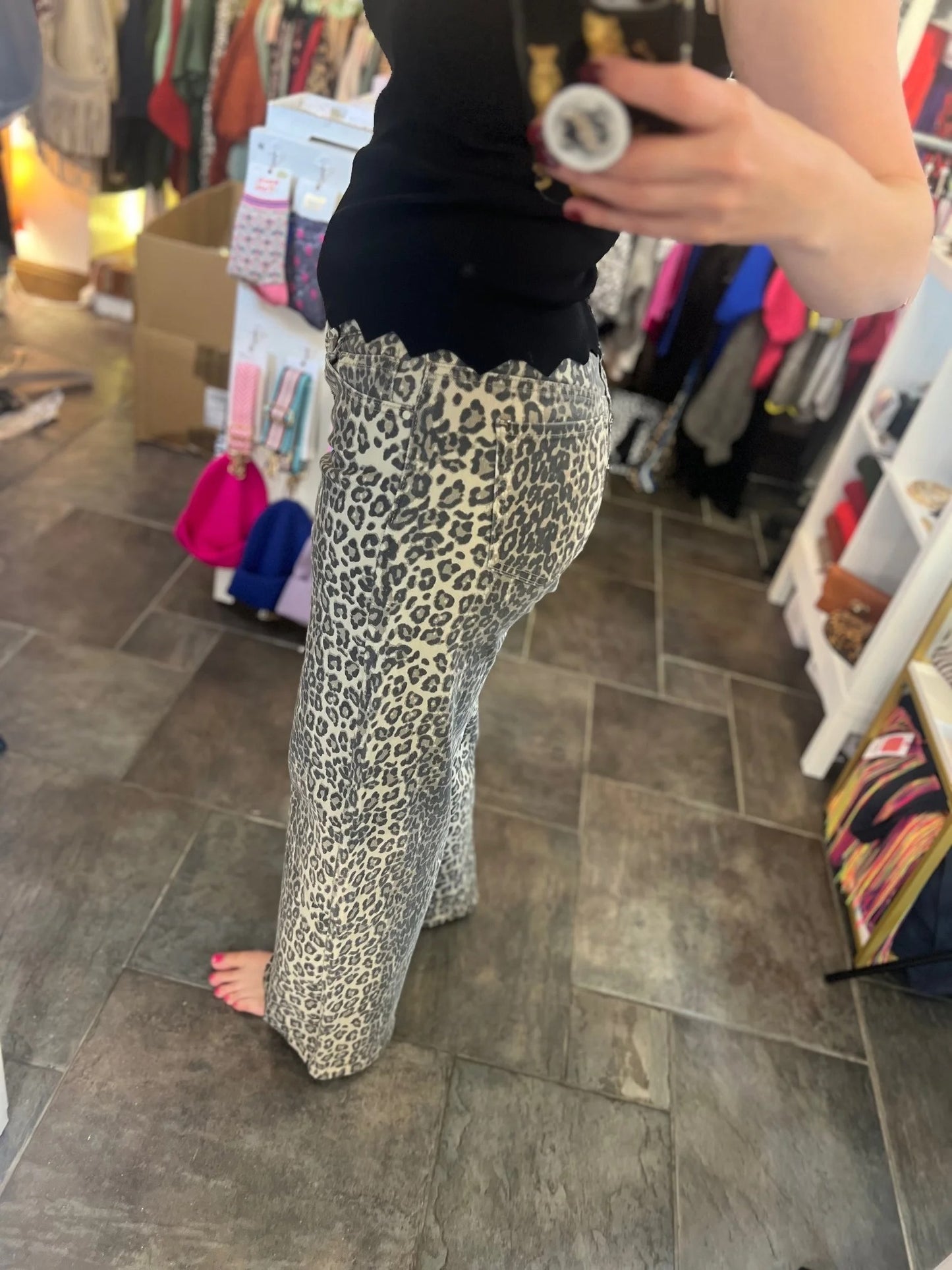 Person wearing leopard print pants in a store setting