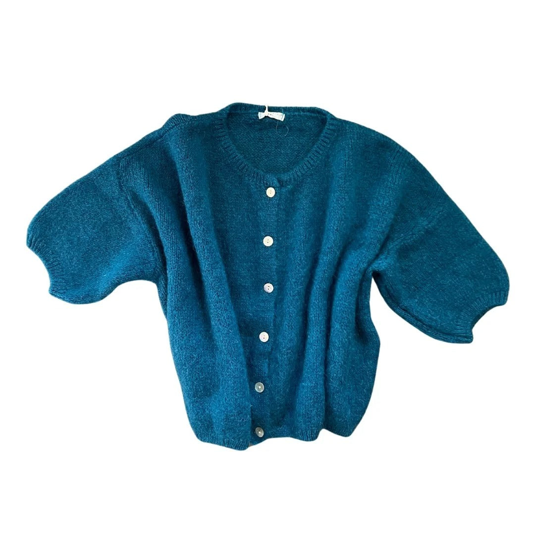 Blue cardigan with white buttons on a white background