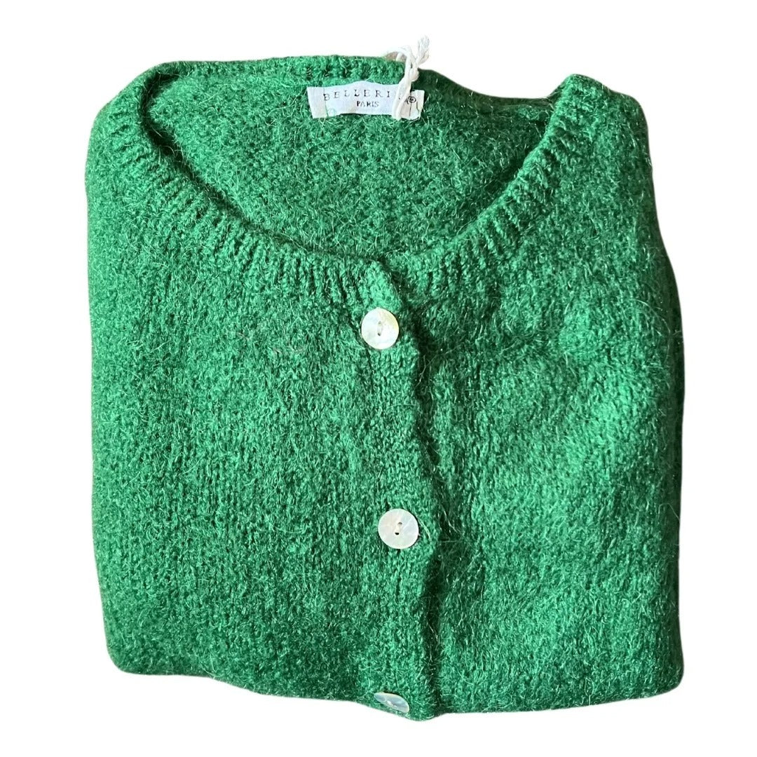 Folded green cardigan with button details on a white background