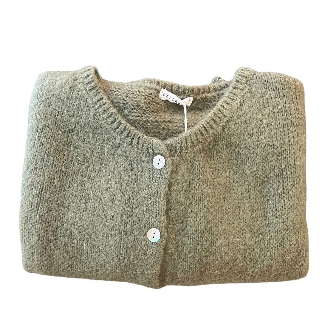 Folded green cardigan with button details on a white background