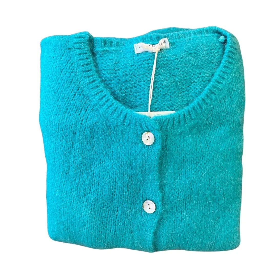 Folded turquoise cardigan with white buttons on a white background