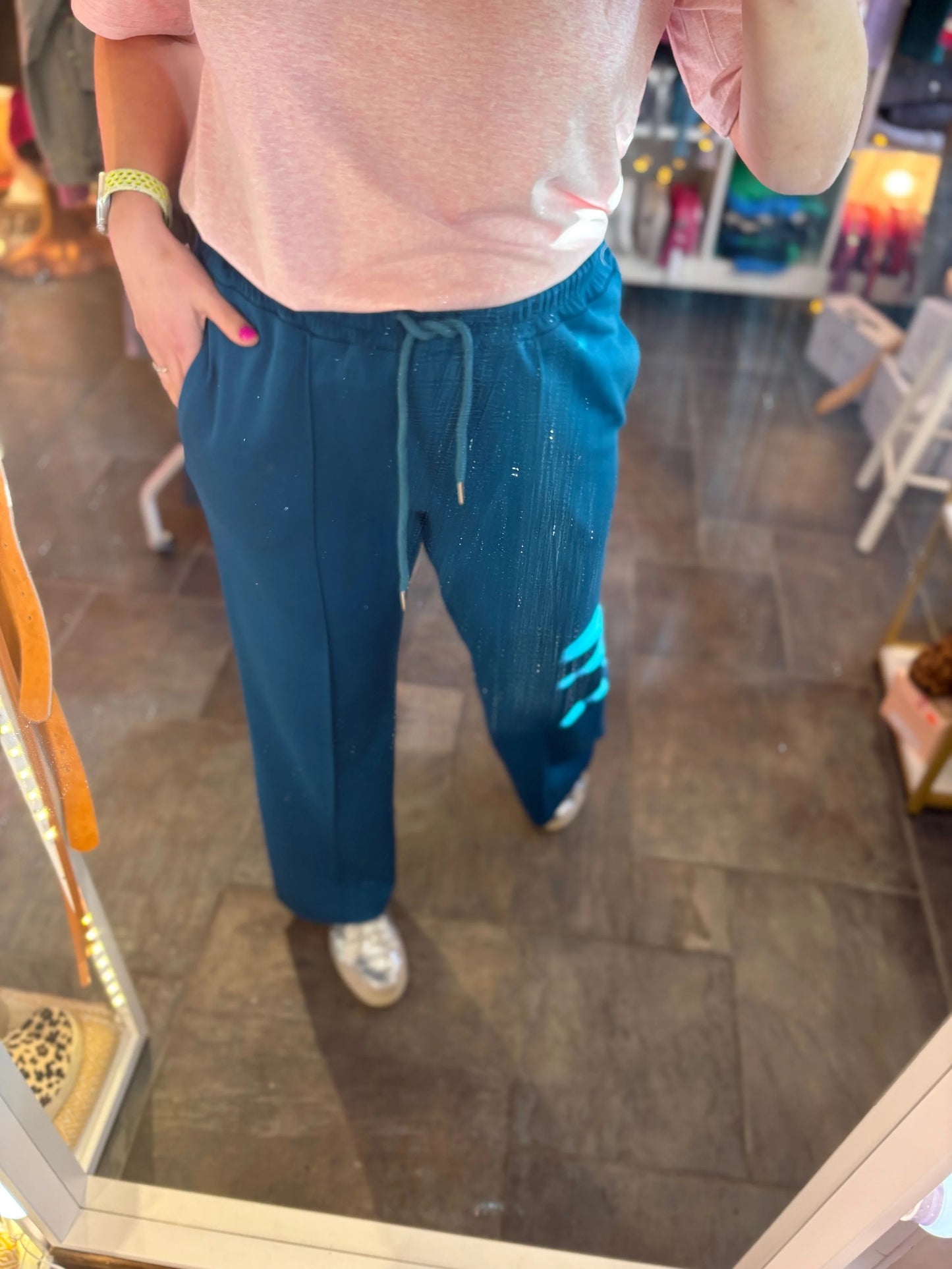 Person wearing blue pants and a pink top in a store setting