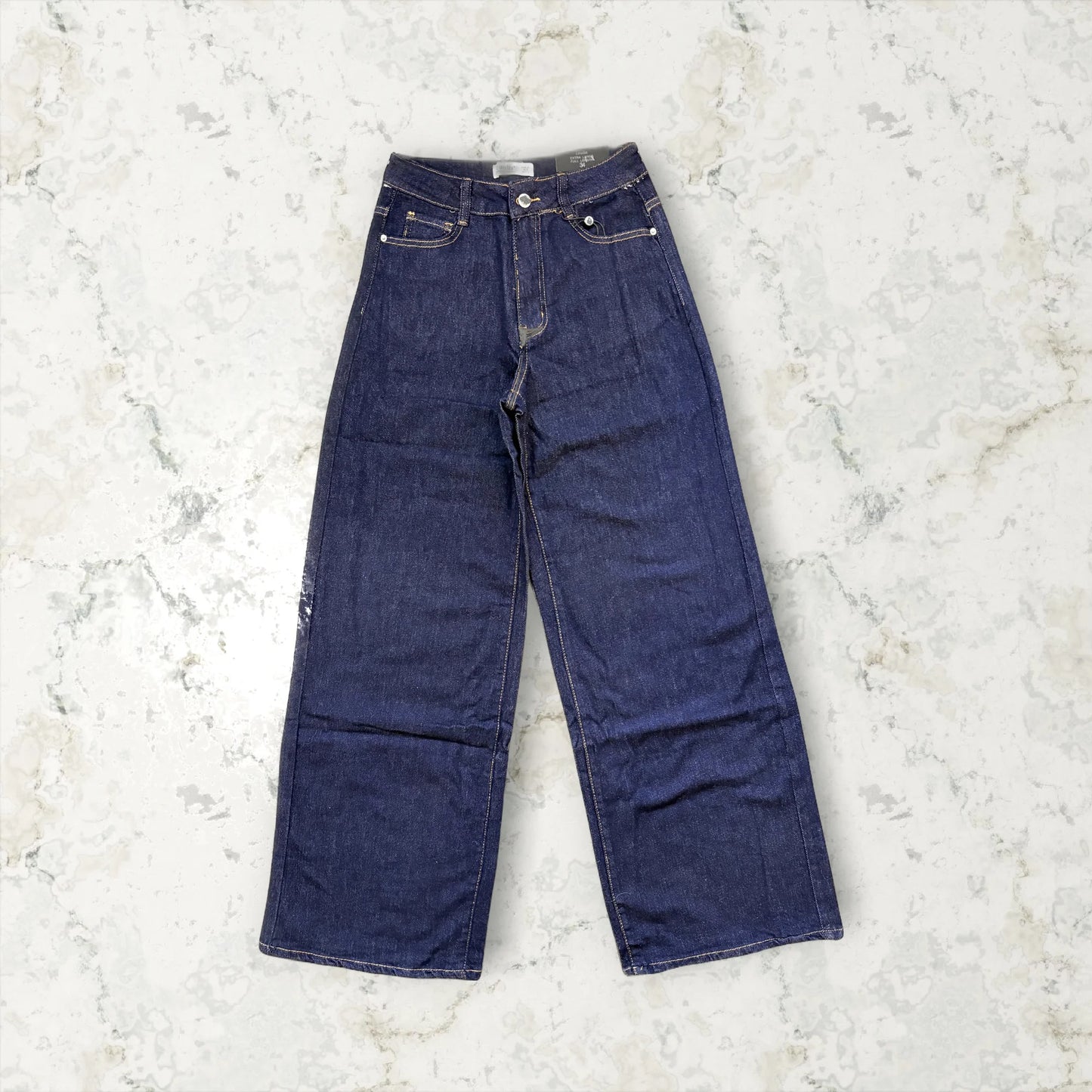 Pair of blue jeans on a light gray textured background