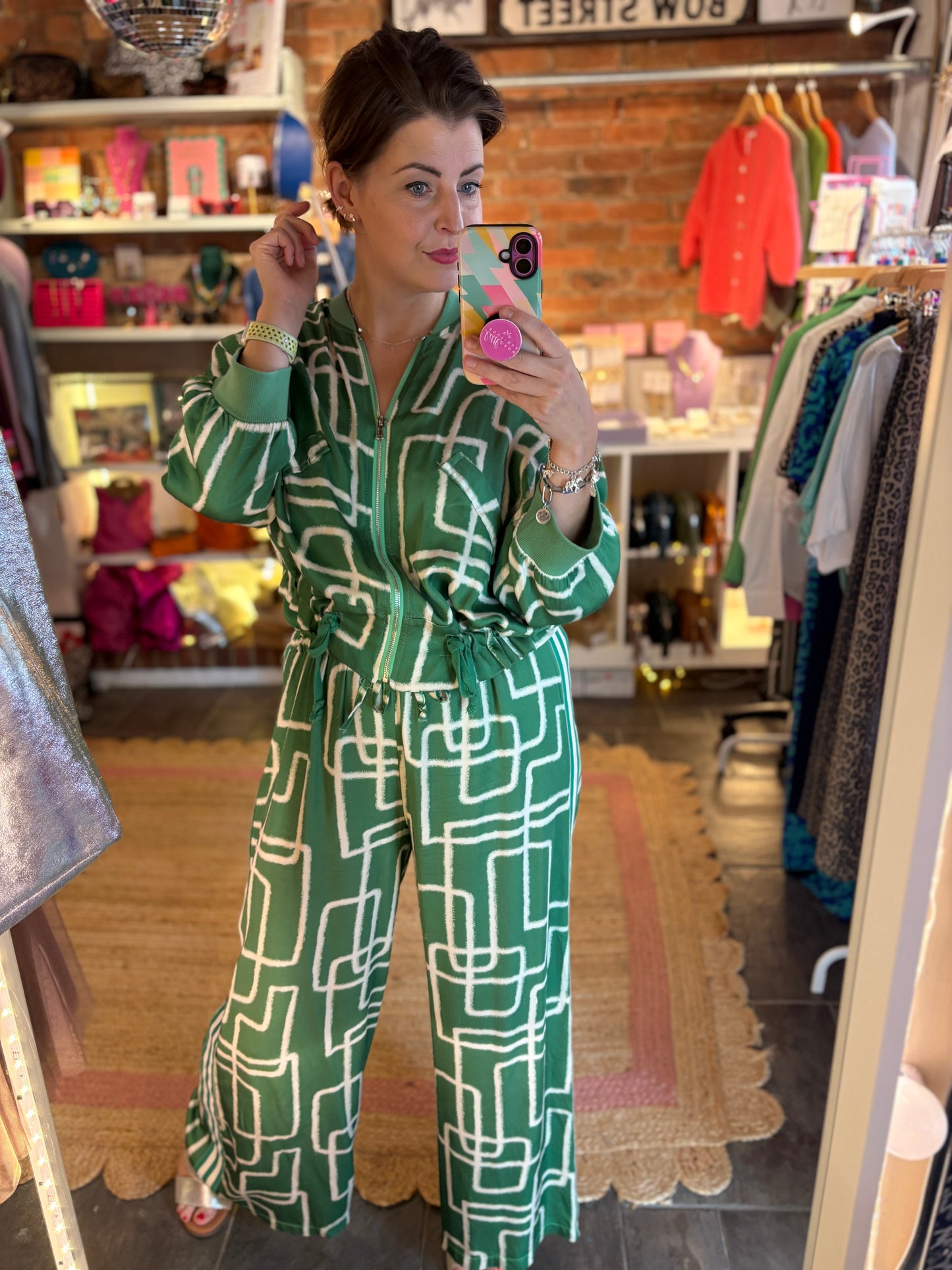 Woman wearing a green patterned co ord outfit in a store setting