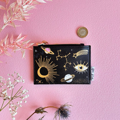 Black pouch with celestial designs on a pink background