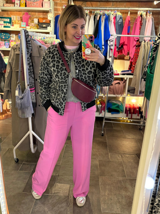 Person wearing a leopard print jacket and pink pants in a store setting