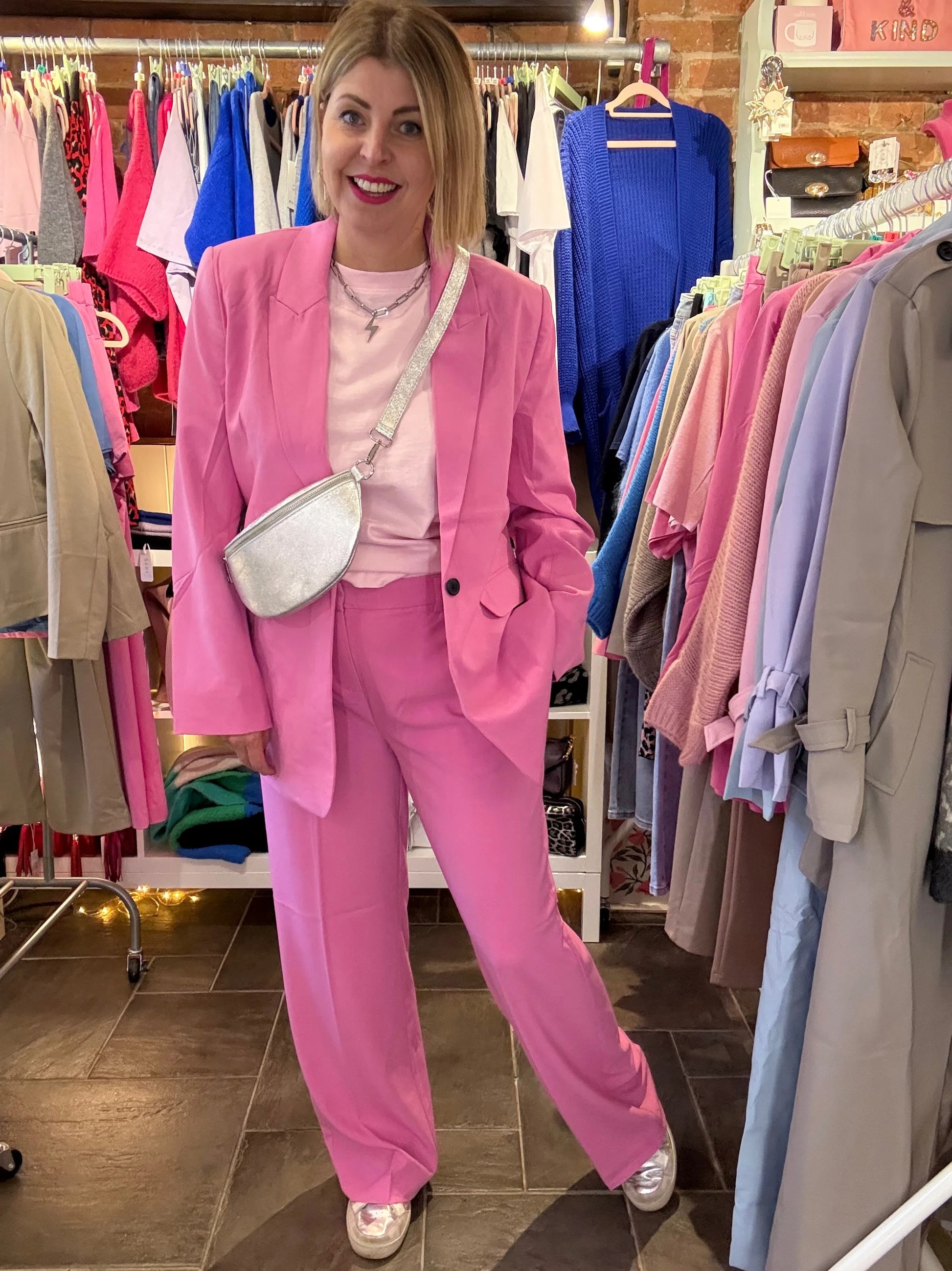 Person wearing a pink suit standing in a clothing store.