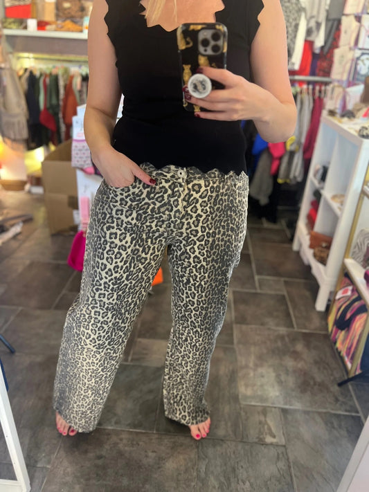 Person wearing leopard print pants and a black top in a store setting