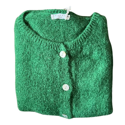 Folded green cardigan with button details on a white background