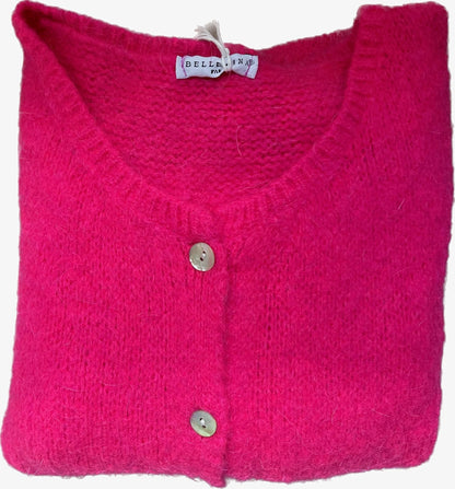 Folded pink knitted cardigan with a brand tag on a white background