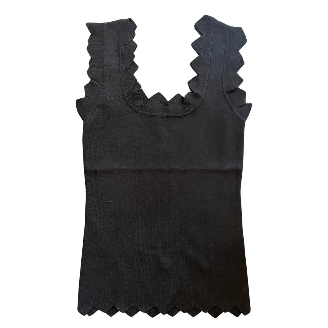 Black tank top with ruffled neckline on a white background