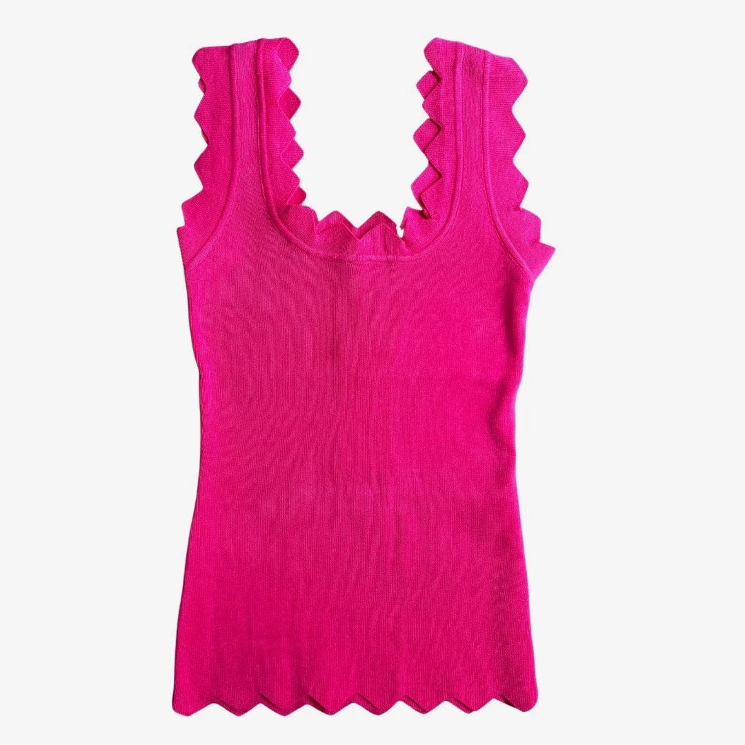 Pink tank top with ruffled neckline on a white background
