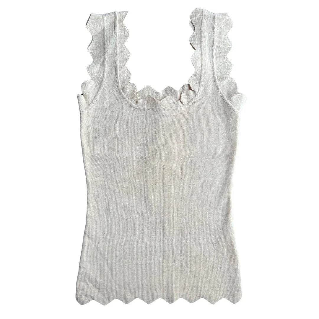 White tank top with ruffled trim on a white background