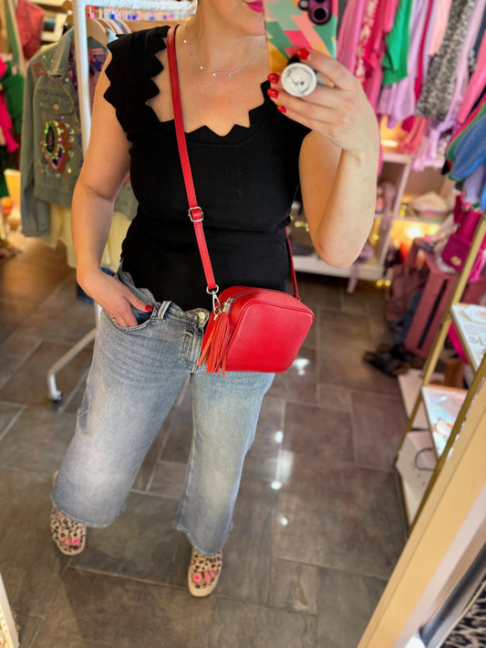 Person holding a red handbag in a store setting