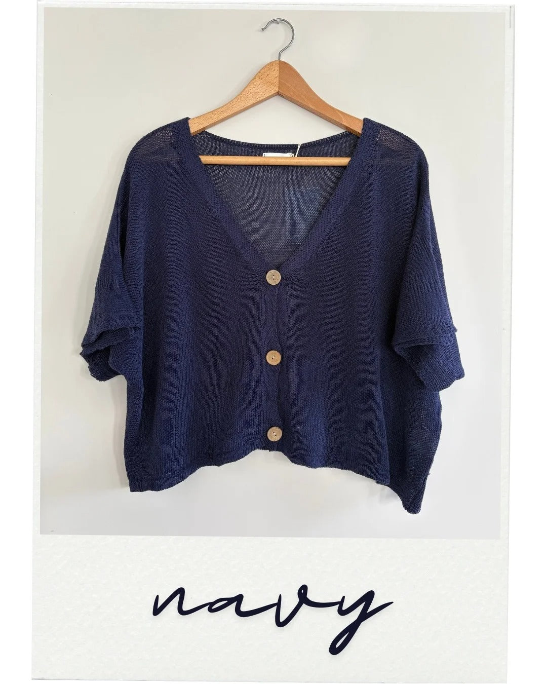 Navy cardigan on a hanger with 'navy' text below