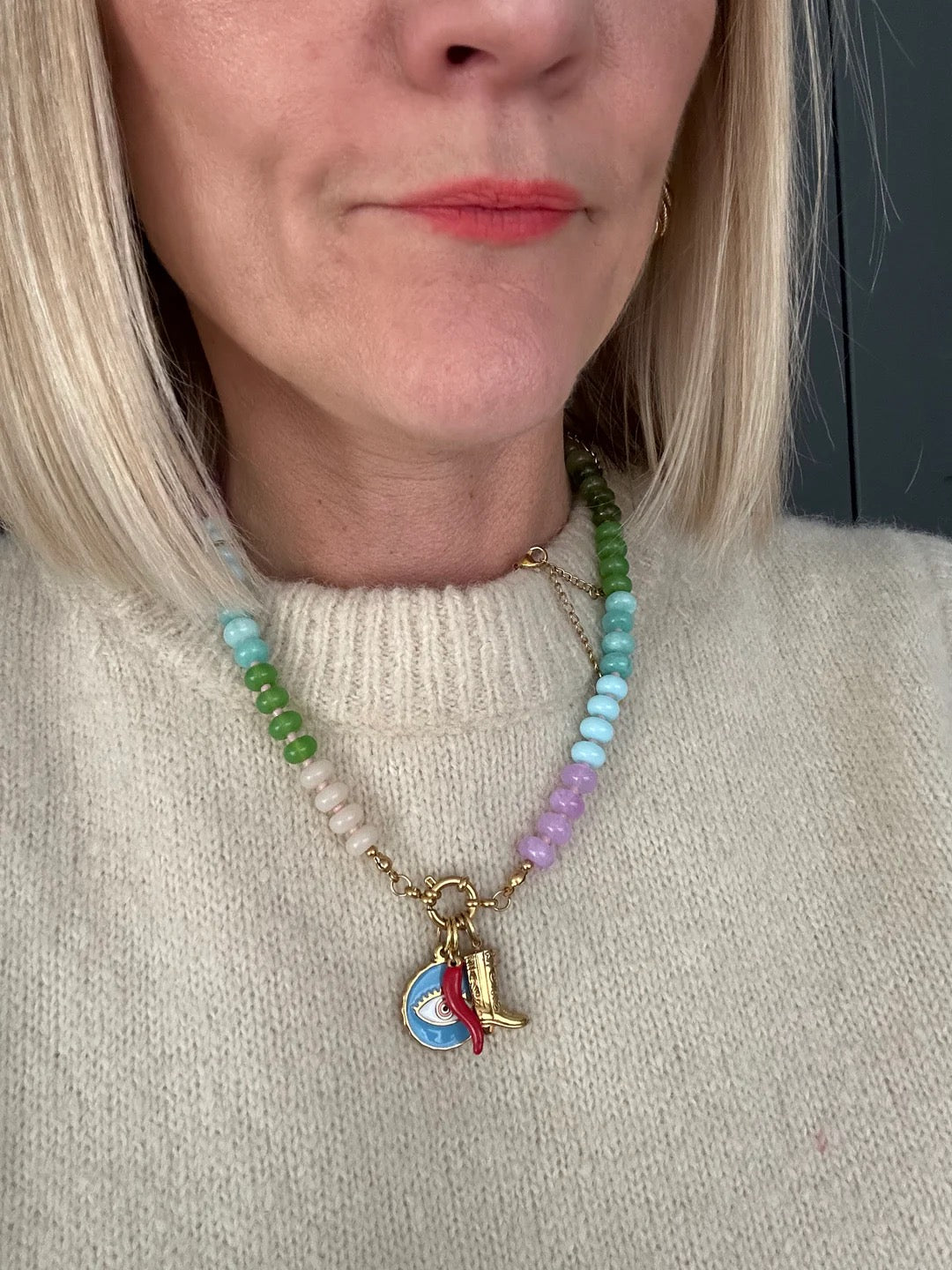 Close-up of a person wearing a colorful beaded necklace with a pendant.
