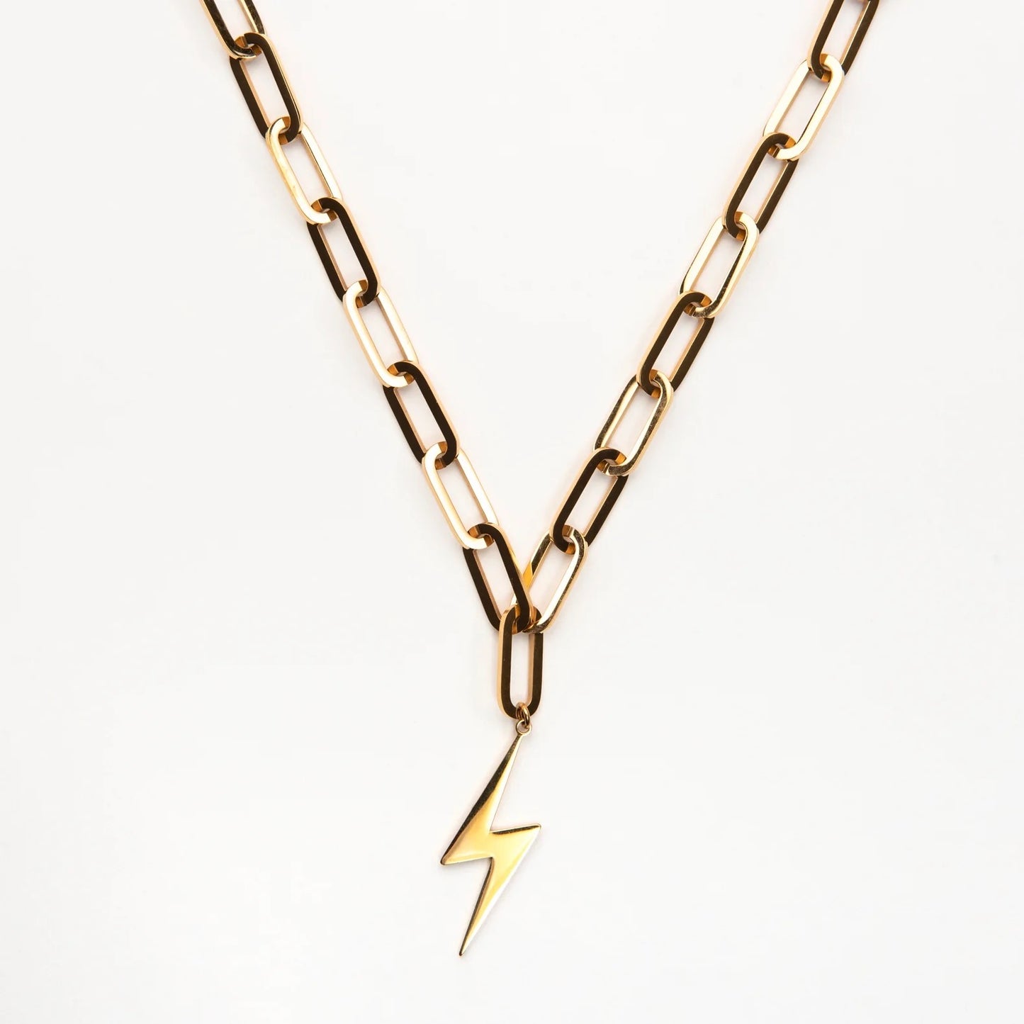 Gold chain necklace with a lightning bolt pendant on a white background