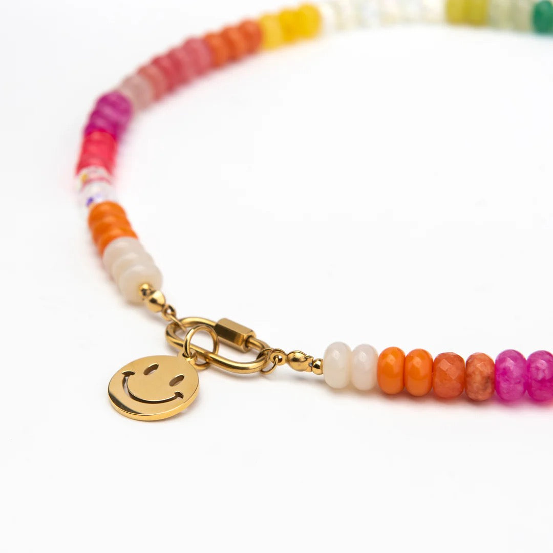 Colorful beaded bracelet with a gold smiley face charm on a white background