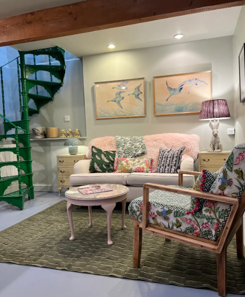 Living room with a sofa, armchair, and decorative elements.