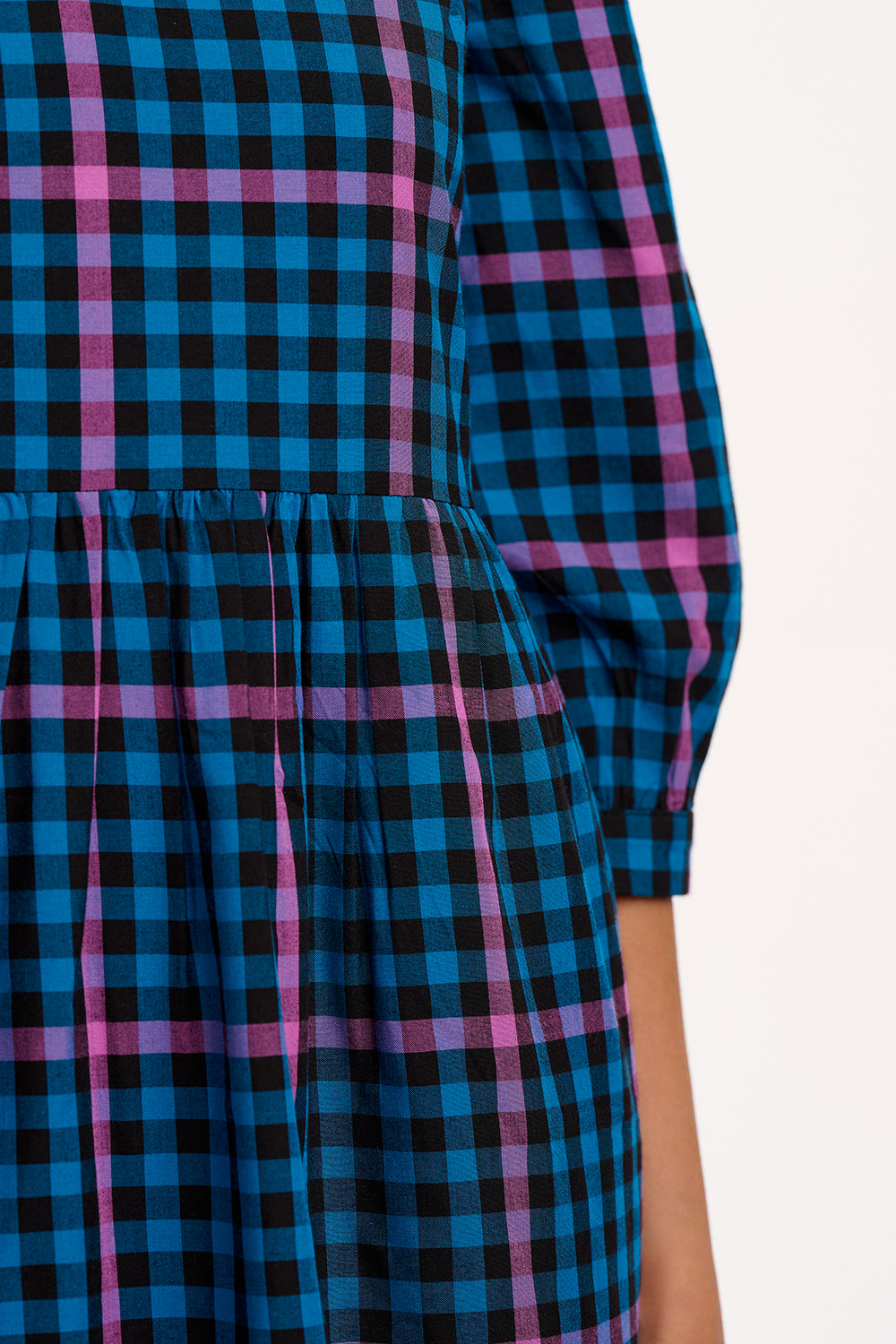 Close-up of a blue and pink plaid dress with a blurred background