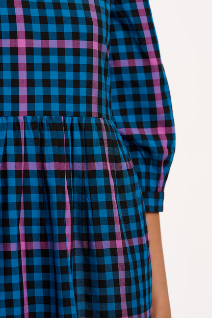 Close-up of a blue and pink plaid dress with a blurred background
